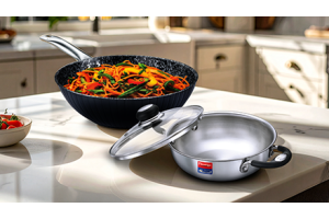 Stainless steel and hard anodized cookware on a kitchen table