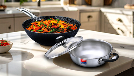 Stainless steel and hard anodized cookware on a kitchen table